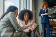 © Miljan Živković - Diverse business women collaborating and networking in office lounge