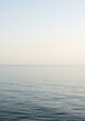 © yuwaree - A vast, uninterrupted seascape where the calm ocean meets the pale, cloudless sky along a perfectly defined, empty horizon line, blank, water, ethereal