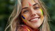 © Nataliia_Trushchenko - Young woman with colorful face paint smiles brightly, showcasing vibrant colors on her cheeks and forehead, surrounded by a blurred green background in an outdoor setting