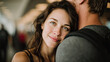 © kora studio - Woman with dark hair and bright eyes embraces man, moment of affection in busy environment. background features blurred figures, emphasizing their connection