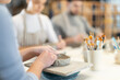 © JackF - Close up unrecognizable femalemaster forms bowl of clay during master class. Team of creative enthusiasts is engaged in clay modeling lesson in background.