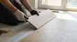 © krismicrostoker - A man is laying down on the floor and cutting a piece of wood