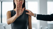 © KAMRAN - Woman holding hand up stopping colleague touching shoulder perfect for workplace harassment prevention and personal boundary defense