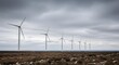 © Aziz - A line of towering wind turbines generating renewable energy against a vast, cloudy sky