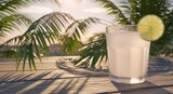 Refreshing drink on wooden surface with palm leaves in sunlight