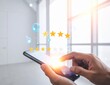 © RADEA STUDIO  - Customer giving five star rating on smartphone for excellent service.