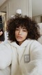 © Evon J - Young hispanic female taking a selfie in cozy setting