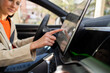 © Westend61 - Person navigating touch screen GPS in car interior