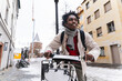 © Westend61 - Smiling man riding bicycle through snowy city street in winter