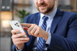 © New Africa - Man using modern smartphone in office, closeup