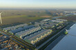 © AmazingAerialAgency - Aerial view of modern data center complex processing vast amounts of information, integrating technology with renewable wind energy in an agricultural area, Middenmeer, Netherlands.