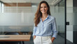 © shahinahmed - A woman in a blue shirt and white pants standing in an office
