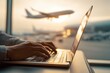 © Lady O - Businessman typing on a laptop at the airport, with an airplane in the background.