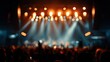 © Syarifuddin - Blurred concert scene with stage lights illuminating a cheering crowd in darkness