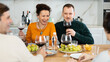 © JackF - Group of happy celebrating holiday drinking and chatting at table at home