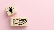 © Gambar - Hand offering an idea lightbulb on wooden blocks, innovation and inspiration concept