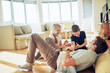 © Geber86 - Father tickling son and daughter on living room floor