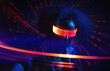 © VISTA by Westend61 - Person wearing neon VR set dancing in nightclub with futuristic lights