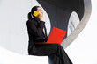 © VISTA by Westend61 - Businesswoman multitasking with smartphone and red laptop in Barcelona