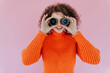 © VISTA by Westend61 - Smiling woman with curly hair holding lenses in front of eyes indoors