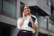 © SISMIZ - Confident businesswoman talking on phone holding tablet