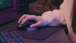 © los3amigos - Una mano sosteniendo un ratón para juegos con iluminación ambiental púrpura, simbolizando el control y la inmersión en el mundo digital.