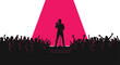 © naim - A silhouetted male singer performs on a small stage under a bright pink spotlight before an excited, cheering crowd.