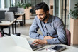 © insta_photos - Smiling indian executive manager working at home watching online learning training webinar for employees. Latin Hispanic student having online virtual video call on computer in coworking space.