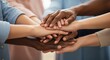 © Emam - A close up view of many diverse people stacking their hands together to show unity and support for their common cause