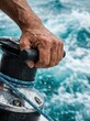 © hobonski - Extreme close-up of a senior hand on a carbon-fiber winch. Sea spray, tanned skin, and high-speed turquoise water. Active elite senior lifestyle.
