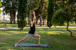 © ADDICTIVE STOCK - Man practicing yoga on mat in green park at sunrise
