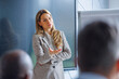 © PeopleVideos - Businesswoman speaking at a corporate presentation, sharing knowledge and leading a discussion with an audience