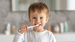 © Taisiia - A cheerful young boy happily brushing his teeth with a bright smile