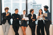 © chokniti - Diverse business team office city window casual formal coworker meeting discussion technology collaboration brainstorming startup urban skyscraper professional colleague workplace corporate tablet