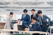 © maroke - オフィスでパソコンを見ながらチームで話す人々