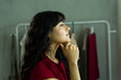 © AntonioDiaz - Young woman getting ready backstage, thinking about her upcoming fashion show or event, preparing for work