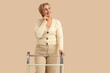 © Pixel-Shot - Thoughtful mature woman with walker on beige background