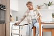 © Pixel-Shot - Mature woman with walker sitting in kitchen