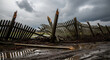 © Violet - Damaged wooden fence collapsing in muddy field under stormy sky