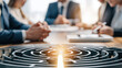 © javu - Business plan team meeting around table with maze concept and goal light