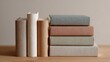 © CYBERPINK - Stack of five books on a wooden surface. the books are arranged in a horizontal line, with the topmost book on the left being a beige-colored book with a white spine.