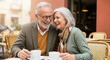 © ipolstock - Happy Senior Couple Laughing and Enjoying Coffee on a Date at an Outdoor European Cafe