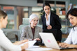 © JackF - Girl instructor oversees new senior female employee during assignment, helps with laptop. Travel agency, regional representative office of international company, engineering company.