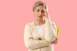 © Pixel-Shot - Mature woman with fan experiencing menopause on pink background