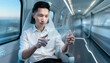 © True Stock - Asian man using futuristic transparent tablet on a highspeed train.