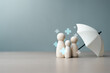 © Garun Studios - Family figures under umbrella symbolizing health insurance coverage, medical protection, and financial support for healthcare and wellbeing.