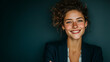 © R2h Stock - portrait of a smiling business woman standing with her arms crossed on a dark green background.