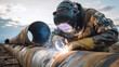 © Алексей Иванченко - Skilled welder in protective gear meticulously joins large industrial pipeline sections outdoors