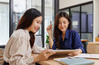 © crizzystudio - Two young businesswomen collaborating studying data on tablet
