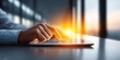 © NovaVision - Close-up of a person's hand using a tablet device with a bright sun flare in the background